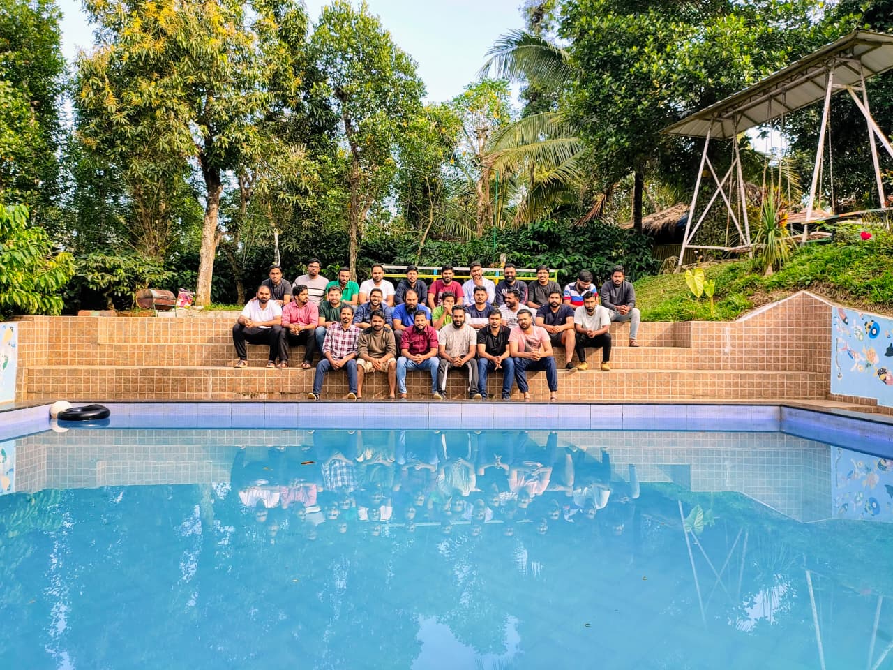 Wayanad Group Tour Packages 2 Friends enjoying a swimming pool getaway at Wayanad Lakeshore Resort in Wayanad