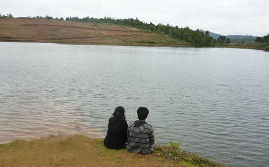 Home 6 Couple enjoying a romantic lakeside honeymoon experience near Karapuzha Reservoir at Wayanad Lakeshore Resort.
